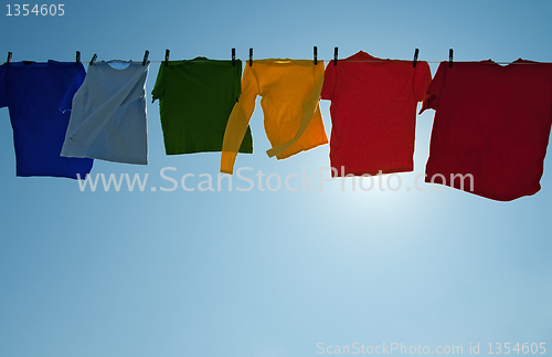 Image of Sun shining through colorful clothes drying in the wind