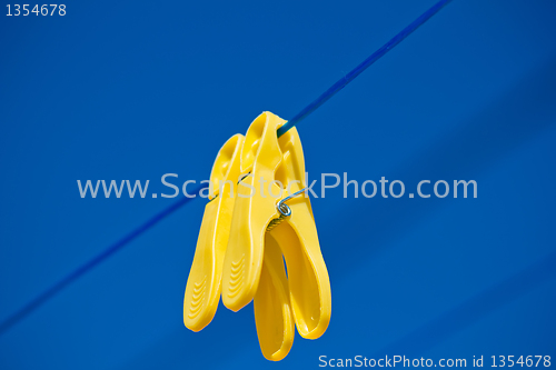 Image of cloth pegs under the clear blue sky