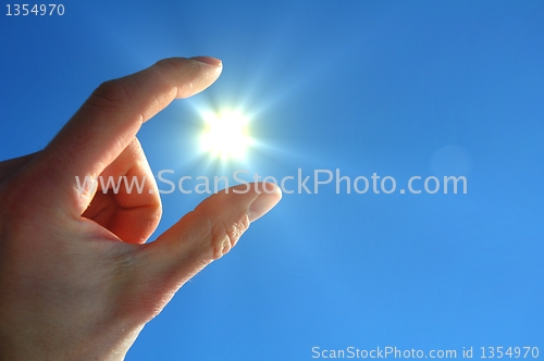 Image of hand sun and blue sky