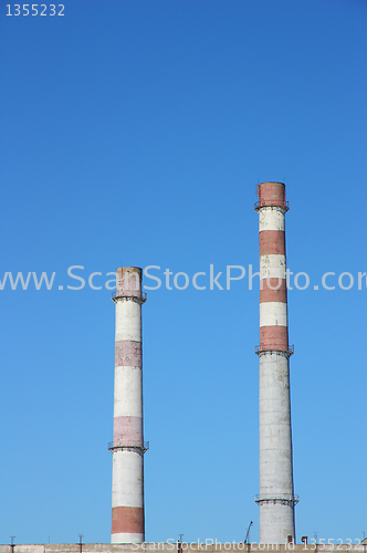 Image of chimneys  large plant against the blue sky