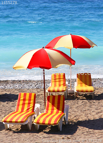 Image of Beach chairs and umbrellas on a sand beach