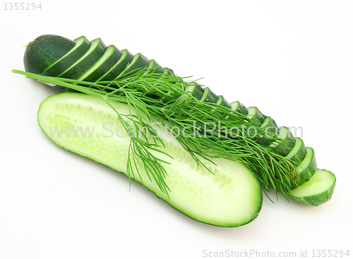 Image of a cucumber with the cut half lying on a dill