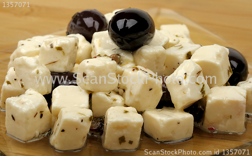 Image of cheese and olives in oil on a plate