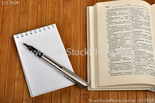 Image of notebook with pen and old Russian-German dictionary