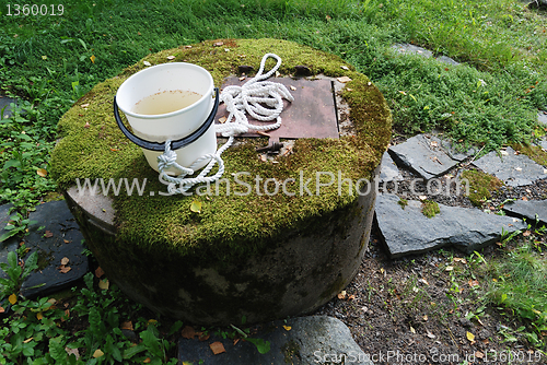 Image of typical concrete water well with moss