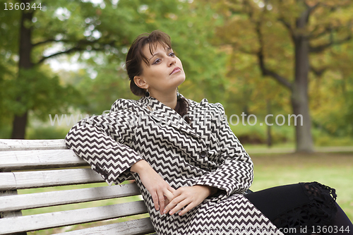Image of young girl relaxing in autumn park