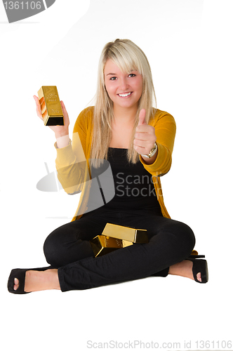 Image of Young girl with goldbar giving thumps up