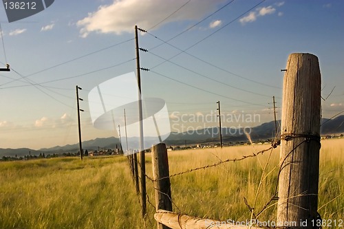 Image of Fence in the Field with Blue Background