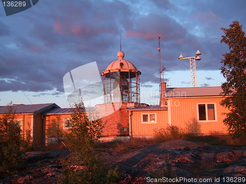 Image of The setting sun shines on a lighthouse