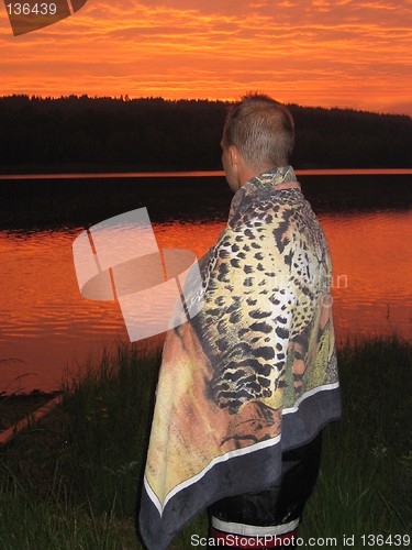 Image of Boy in blanket watching the sunset