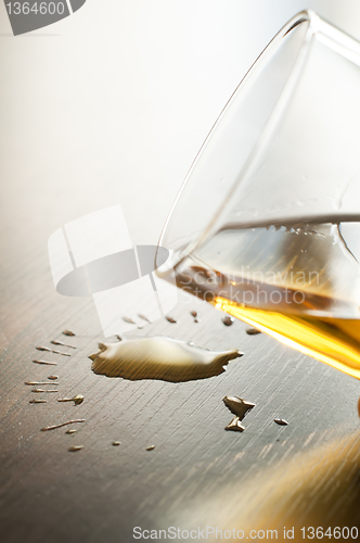 Image of Glass with whiskey and drops on the table