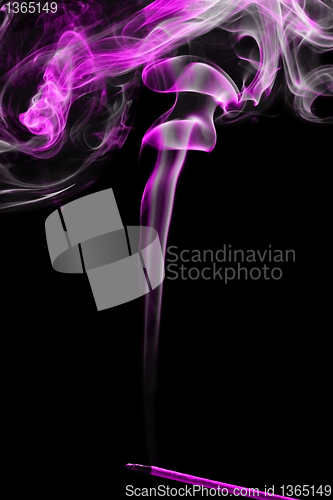 Image of incense stick with smoke over black