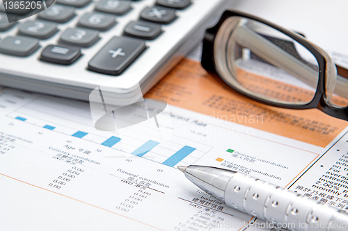 Image of Stock chart with calculator,pen and eyeglasses 