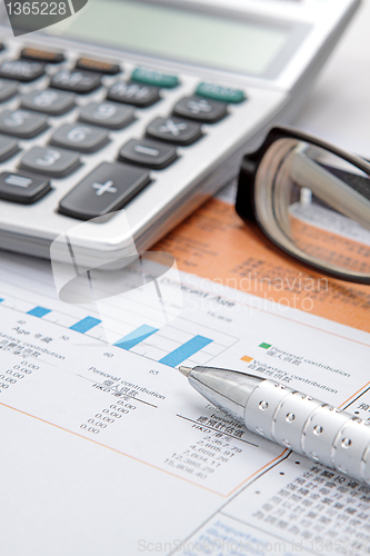 Image of Stock chart with calculator,pen and eyeglasses 