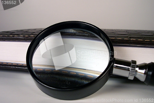 Image of magnifying glass and leather notebook