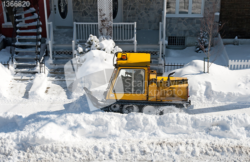 Image of Yellow snowplough removing snow in the city