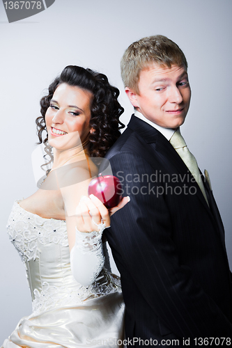 Image of bride offering a red apple to doubting groom