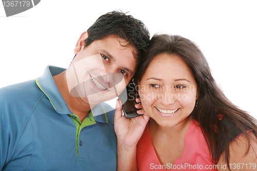 Image of Couple are listening to a friend on a cell phone. 