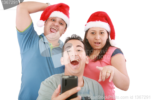 Image of Young friends looking shocked at cell phone with Christmas hat