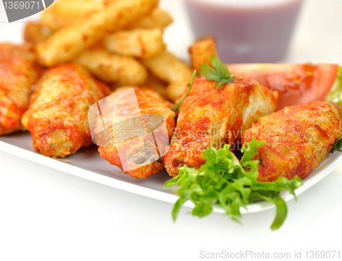 Image of hot chicken wings with fried potatoes and sauce 