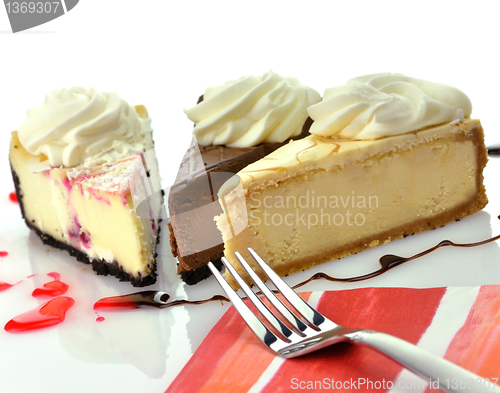 Image of slices of cheesecakes with fork and napkin 