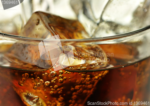 Image of cola with ice cubes close up 