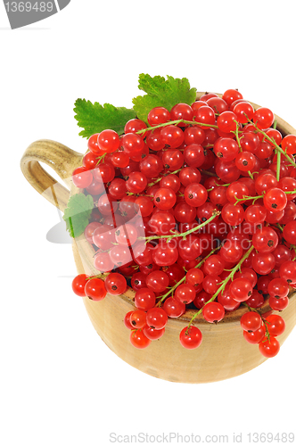 Image of Ceramic cup full of fresh red currant berries. Clipping path included