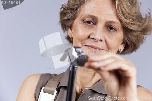 Image of Senior woman driving a nail