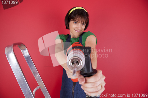 Image of Stressed woman holding a electric drill