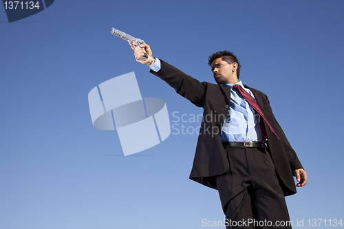 Image of Businessman aiming a handgun