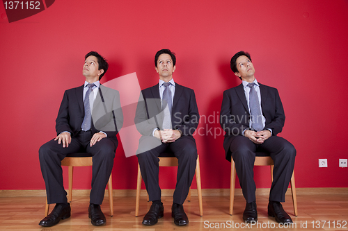 Image of Three twin businessman waiting