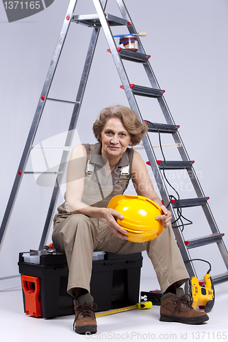 Image of Senior woman sitting in a toolbox