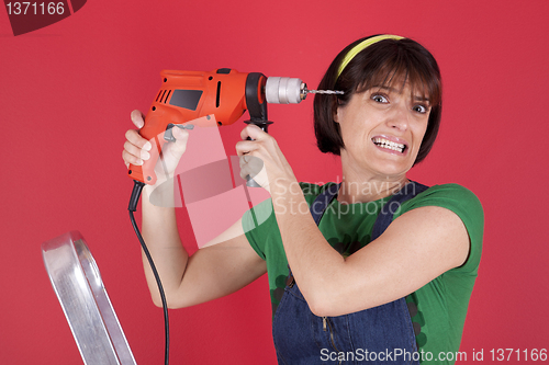 Image of Stressed woman holding a electric drill