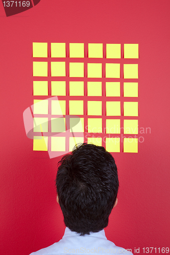 Image of Businessman looking to yellow papers 