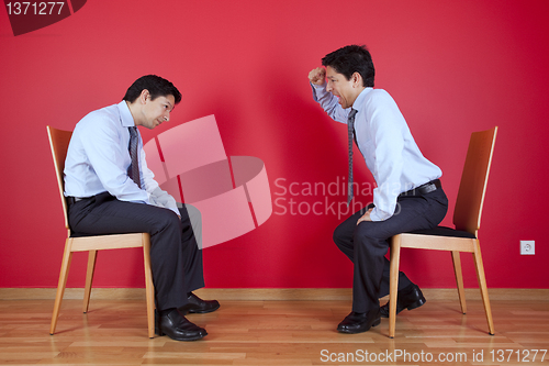 Image of Twin businessman fighting