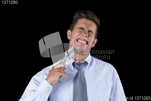 Image of Businessman aiming a handgun at his head