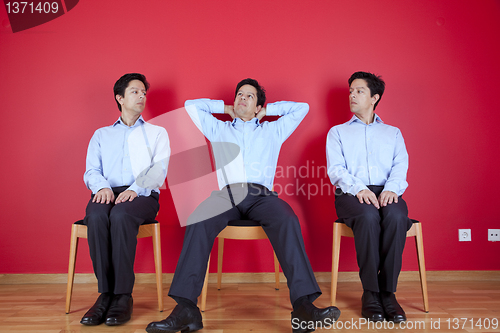 Image of Three twin businessman waiting