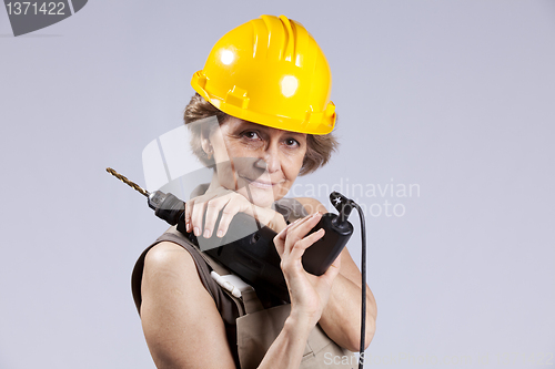 Image of Senior woman with a drill tool