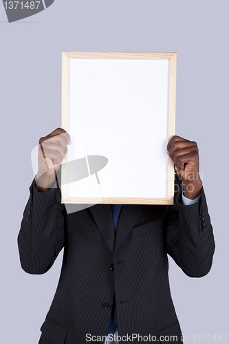Image of african businessman holding a whiteboard