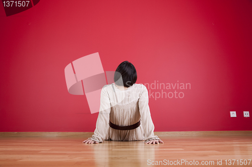 Image of Woman looking to a red wall