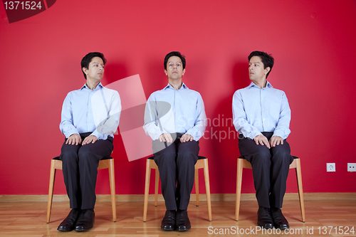 Image of Three twin businessman waiting