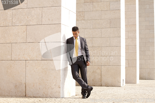 Image of Sad businessman relaxing next to some wall