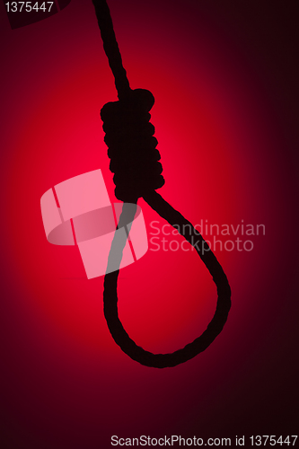 Image of Silhouetted Hangman's Noose Over Red Background