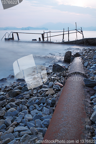 Image of old metal pipe and road to sea