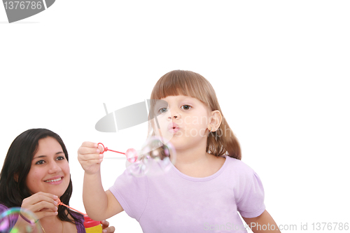Image of Portrait of funny lovely little girl blowing soap bubbles with h