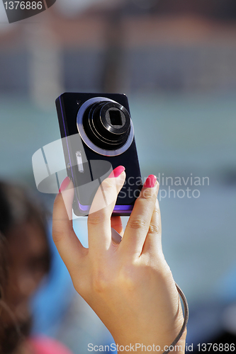 Image of Tourist's hands holding digital photo camera on vacations