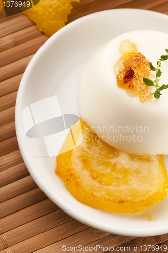 Image of Vanilla Panna Cotta Dessert with lemon and fresh herbs