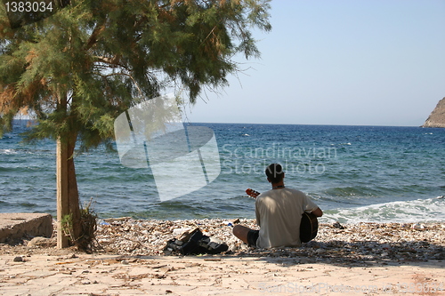 Image of playing the guitar on the beach Tilos Greece