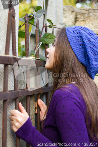 Image of Girl looking through fence