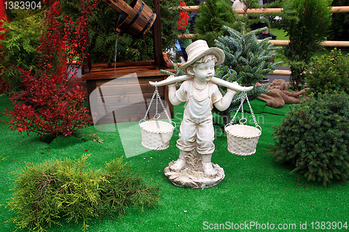 Image of toy boy carries baskets through field